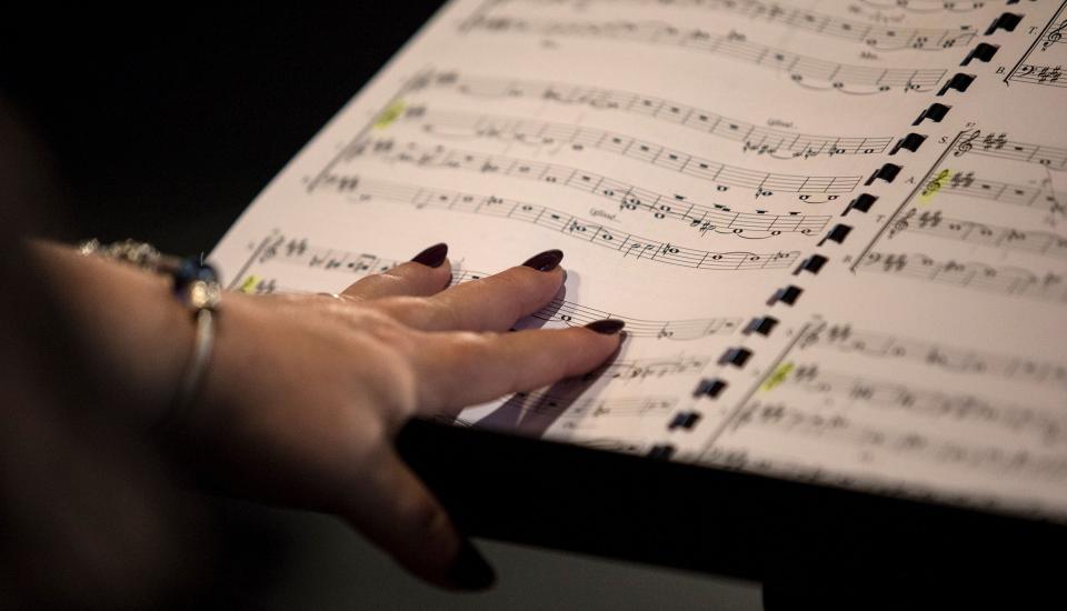 Des voix derrière les murs Une main de femme se pose sur une partition de musique